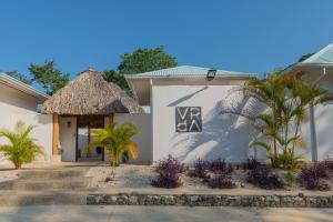 een villa met een rieten bord aan de zijkant van een gebouw bij Villas VR Beachwalk Avellanas in Playa Avellana