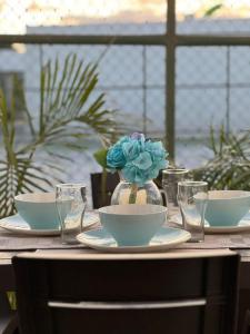里奧阿托的住宿－Beach-Style Pool Villa Paradise，一张桌子,上面有盘子和一个花瓶,上面有蓝色的花