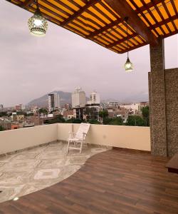 balcón con silla y vistas a la ciudad en Apartamentos Valery en Trujillo