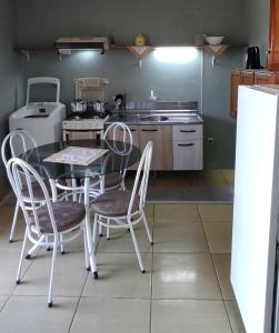 cocina con mesa, sillas y nevera en uma casa na viagem, en Três Cachoeiras