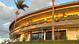 a building with palm trees in front of it at Hotel Casa Redonda Boutique Spa in Campos do Jordão