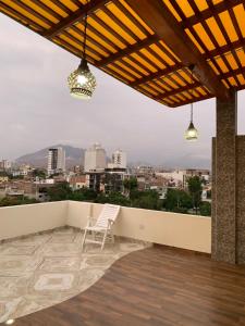 a chair on a balcony with a view of a city at Apartamentos Valery in Trujillo