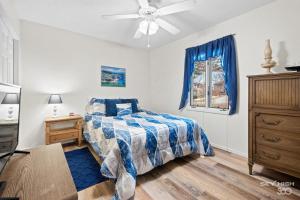 a bedroom with a bed and a ceiling fan at Blue Door Cottage at Scotsdale in Bella Vista