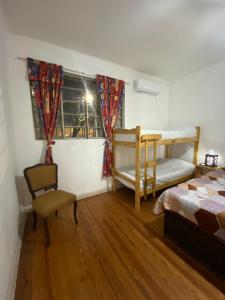 a bedroom with two bunk beds and a chair at Houselyon in Mendoza