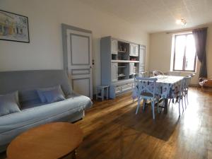 ein Wohnzimmer mit einem Sofa und einem Tisch in der Unterkunft Gîte Les Ressuintes, 3 pièces, 5 personnes - FR-1-581-37 