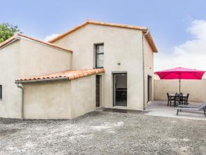 a house with a patio and a red umbrella at Maison calme, rénovée, proche Clisson – 3 chambres, terrasses, jardin, pétanque, stationnement privé - FR-1-306-1208 in Clisson