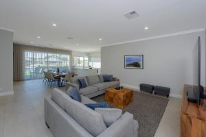 uma sala de estar com dois sofás e uma televisão em A Waterside Paradise - Geographe's Hidden Oasis em Geographe
