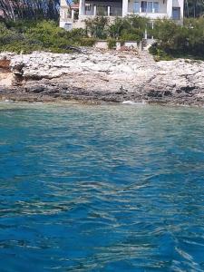 a body of water with a house in the background at Seaside holiday house Cove Tri luke, Korcula - 22092 in Vela Luka