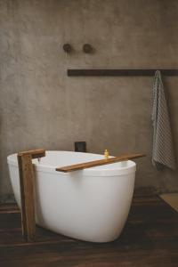 a white bath tub sitting in a bathroom at Paru Boutique Hotel in São Miguel dos Milagres