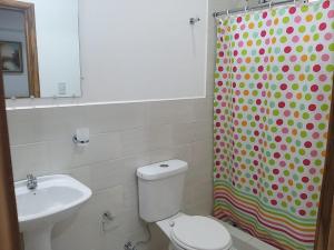 y baño con aseo, lavamanos y cortina de ducha. en Nueva Tierra, Ayampe-Suite en Las Tunas