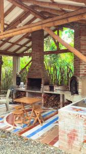 patio con chimenea de ladrillo y mesa de madera en Nueva Tierra, Ayampe-Suite en Las Tunas