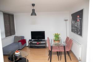 a living room with a couch a table and a tv at Large and bright one bedroom apartment with free parking! in London