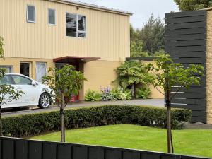 a white car parked in front of a house at Golden Leaf Apartments in Invercargill