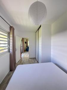 um quarto com uma grande cama branca e uma janela em Âpara Feti'a - Mirimiri Lodge em Tevaitoa