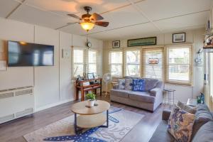 uma sala de estar com um sofá e uma televisão em Historic Nautical Retreat Steps From Beach and Bites em Avalon