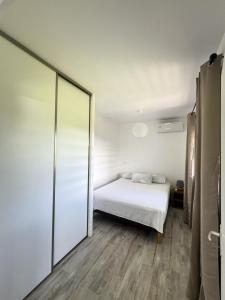 um quarto com uma cama e uma porta de vidro deslizante em Âpara Feti'a - Mirimiri Lodge em Tevaitoa