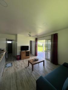 uma sala de estar com um sofá e uma mesa em Âpara Feti'a - Mirimiri Lodge em Tevaitoa