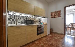 a kitchen with wooden cabinets and a refrigerator at Stunning Apartment In Chiaramonte Gulfi With Wi-fi in Chiaramonte Gulfi