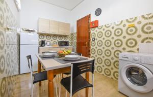 cocina con mesa y lavadora en Pet Friendly Apartment In Chiaramonte Gulfi With Wifi en Chiaramonte Gulfi