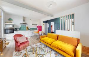 Una sala de estar con un sofá amarillo y una cocina. en Nice Home In Royan With Wifi, en Royan