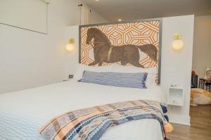1 dormitorio con 1 cama con una foto de un caballo en la pared en The Hive 201 King Suite en Wilmington