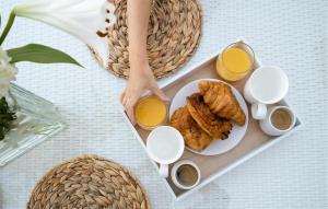 a table with a plate of food and two cups of orange juice at 2 Bedroom Awesome Home In Les Mées in Les Mées