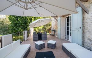 eine Terrasse mit weißen Möbeln und einem Sonnenschirm in der Unterkunft Beautiful Home In Les Mes With Outdoor Swimming Pool in Les Mées