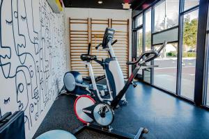 un gimnasio con 2 bicicletas estáticas y una pared con graffiti en The Hive 201 King Suite en Wilmington