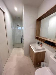 a white bathroom with a sink and a shower at Four-Bedroom Town House in Port Melbourne in Melbourne