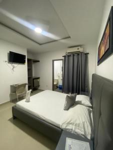 um quarto com uma cama e uma televisão na parede em Hotel Don Felipe em Ríohacha