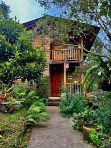 Casa con porche de madera y balcón. en Beehouse Arví Cabaña, en Guarne
