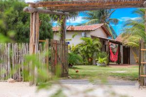 een huis aan het strand met een houten hek bij Pousada Vila Bella in Ponta do Anel