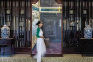 a woman walking in front of a door with vases at Wyndham Garden Hoi An Cua Dai Beach in Hoi An
