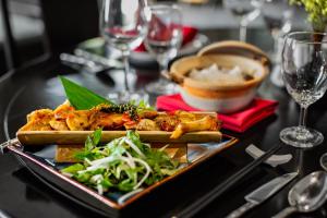 a table with a plate of food on a table at Wyndham Garden Hoi An Cua Dai Beach in Hoi An
