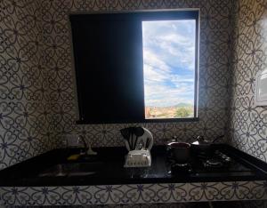 a bathroom with a sink with a window above it at Âncora Lofts in Arraial do Cabo +30 photos
