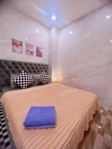 um quarto com uma cama grande e uma almofada azul em MIS HOSTEL Cần Thơ em Can Tho