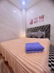 1 dormitorio con 1 cama grande con almohada morada en MIS HOSTEL Cần Thơ, en Can Tho