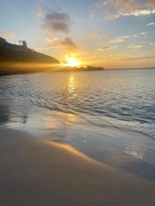 um pôr do sol na praia com o pôr do sol em Casa com piscina cabo frio em Cabo Frio