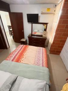 1 dormitorio con 1 cama con tocador y espejo en Apartamento Aeropuerto Maiquetia en Planta Baja, en Catia La Mar