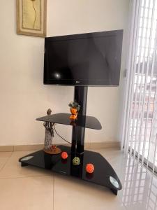 einen schwarzen Stand mit einem Flachbild-TV darüber in der Unterkunft Apartamento Aeropuerto Maiquetia en Planta Baja in Catia La Mar