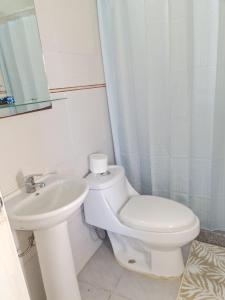 een witte badkamer met een toilet en een wastafel bij Apartamento 2 casa D'Furia in Colonia del Sacramento