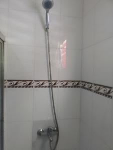 y baño con ducha con cabezal de ducha. en Típica casa dominicana a 12 minutos de la playa, en Las Galeras