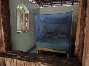 a bed in a room with a blue canopy at Posada Piedra de Fuego in Zipolite