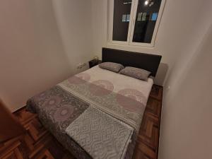un piccolo letto in una camera da letto con finestra di Dunja ambient a Kraljevo