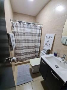 a bathroom with a sink and a toilet and a sign at Beach-Style Pool Villa Paradise in Río Hato
