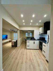 a large kitchen with white cabinets and a living room at Casa Del Cable Carril in Chilecito