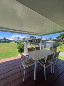 einen Tisch und Stühle auf einer Terrasse mit Aussicht in der Unterkunft Painapoo - Mirimiri Lodge in Tevaitoa