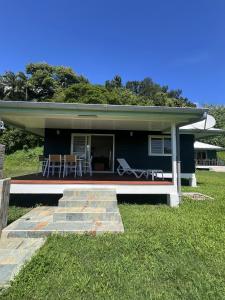 ein blaues Haus mit einer Veranda und einer Terrasse in der Unterkunft Painapoo - Mirimiri Lodge in Tevaitoa