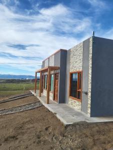 una casa costruita con un campo sullo sfondo di Jardines del Calafate a El Calafate