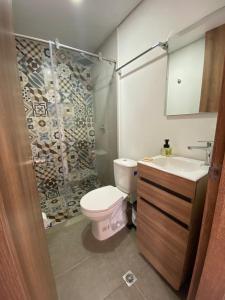 y baño con aseo, lavabo y ducha. en Apartamento 202 en Guatavita
